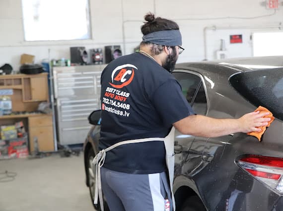 Auto body technician buffing and polishing vehicle at Las Vegas shop