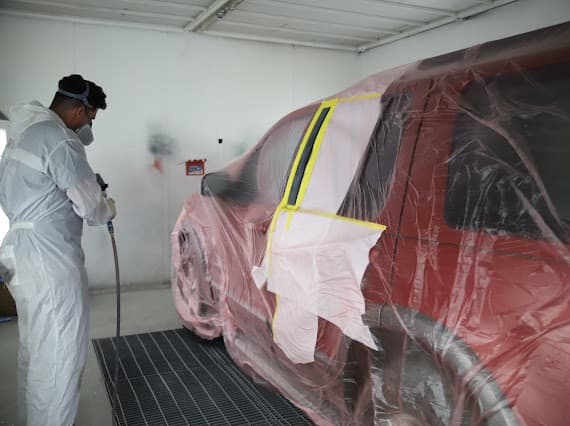 Auto paint refinishing technician spraying vehicle in Las Vegas