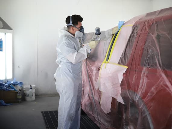 Auto paint technician in protective gear at Best Class Auto Body Las Vegas